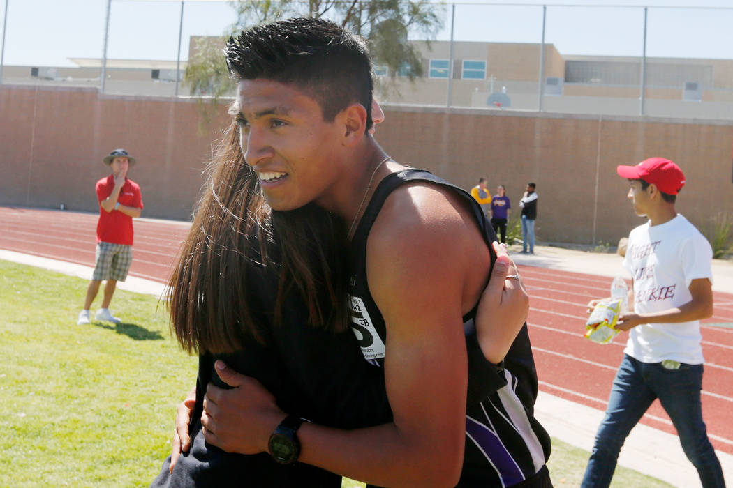 Silverado senior runner Omar Aguilar-Espinoza (5) hugs his teammate Ashley Nekoba after winn ...