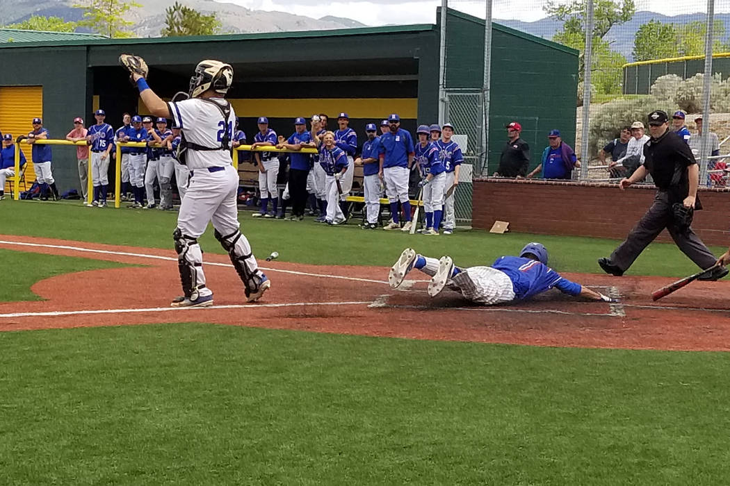 Reno’s Sawyer Jaksick dives across home plate with the lone run against Basic in the C ...