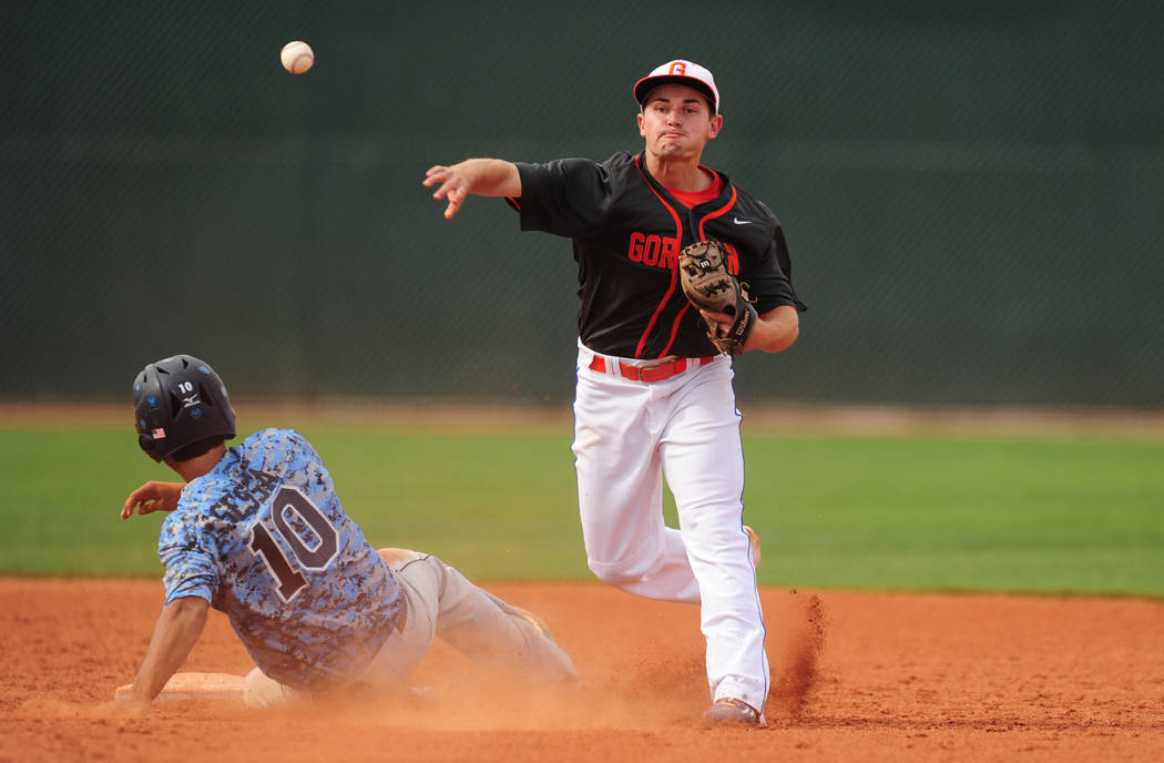 Bishop Gorman shortstop Beau Capanna turns a double play while Centennial base runner Frank ...