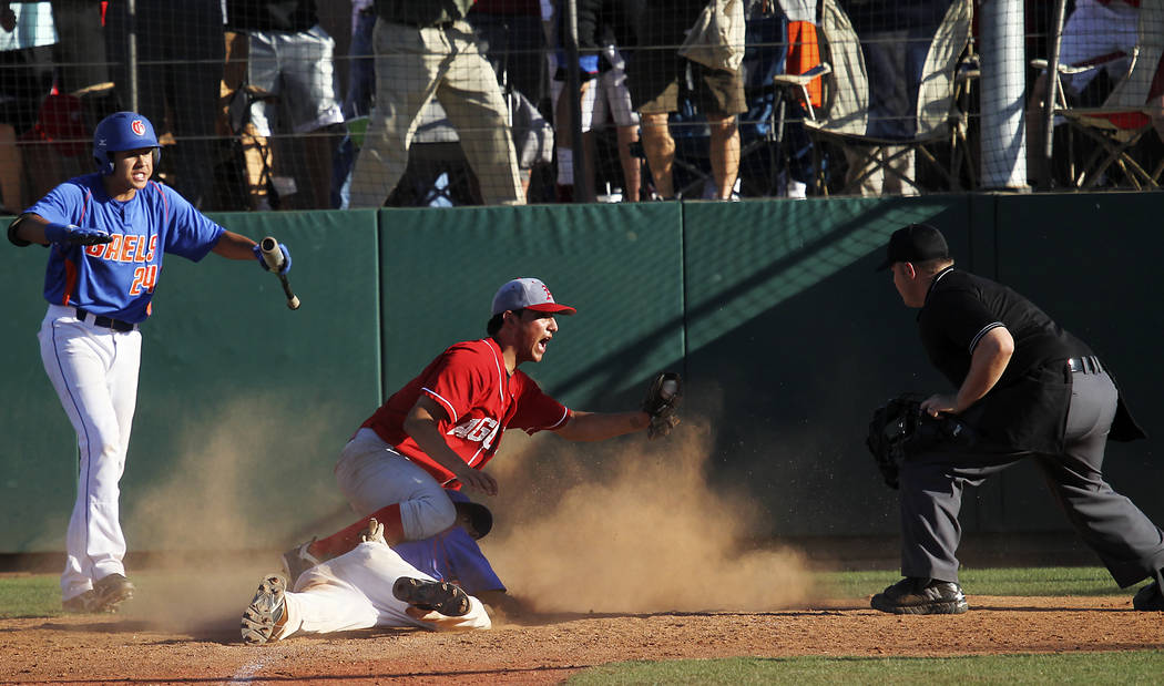 Arbor View’s Zach Quintana shows the ball to the umpire after tagging out Bishop Gorma ...