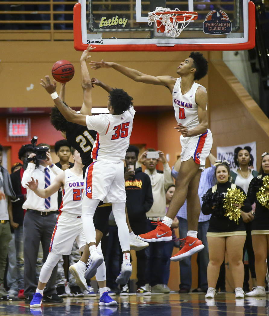 Bishop Gorman’s Jamal Bey (35) and Isaiah Cottrell (0) block a shot from Clark’s ...