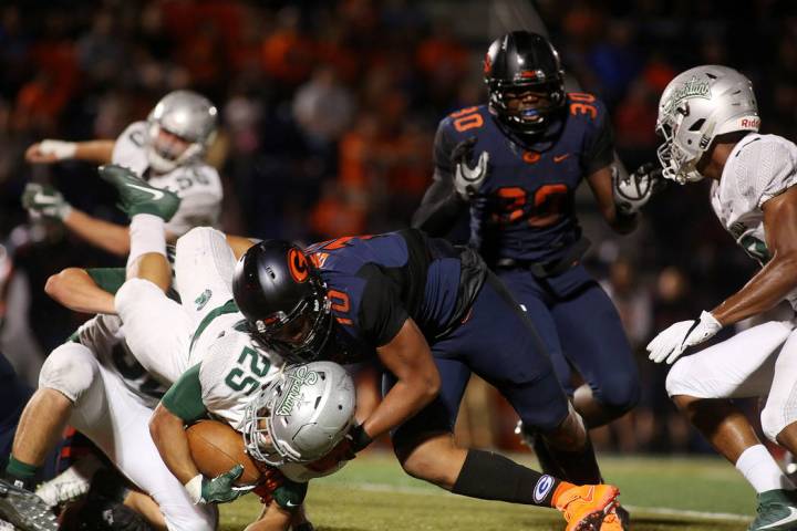 Bishop Gorman player Palaie Gaoteote (10) tackles De La Salle player Kairee Robinson (25) du ...