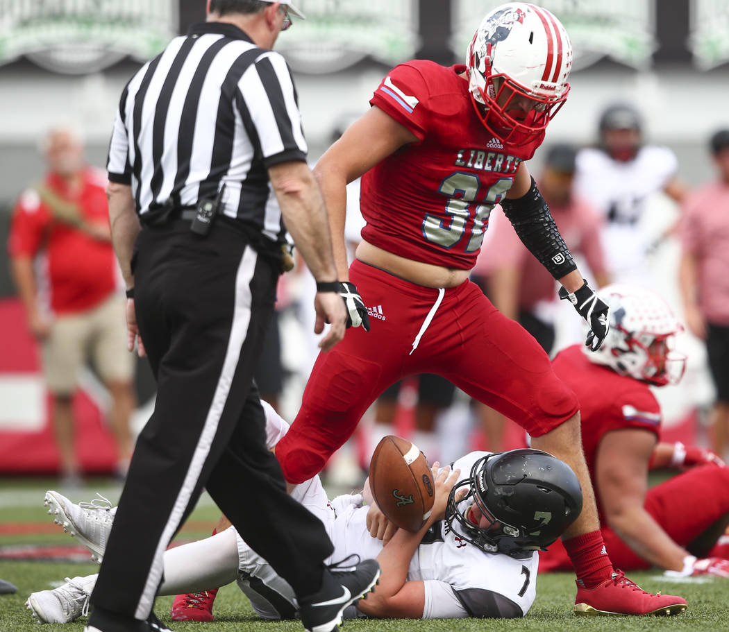 Alta’s Will Dana (7) is sacked by Liberty’s Kyle Beaudry (32) during a football ...