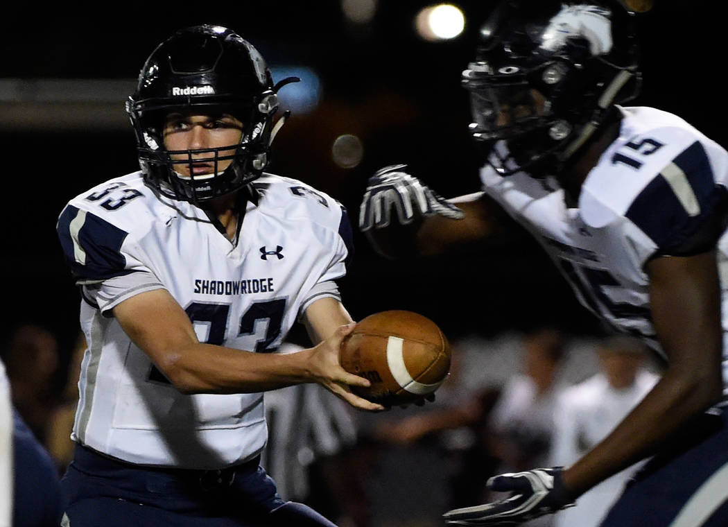 Shadow Ridge quarterback Kody Presser (33) hands the ball off to running back Malik Lindsey ...