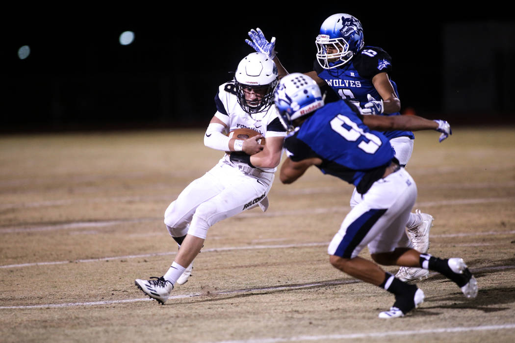 Foothill’s Koy Riggin (18), left, runs before being tackled by Basic during the second ...