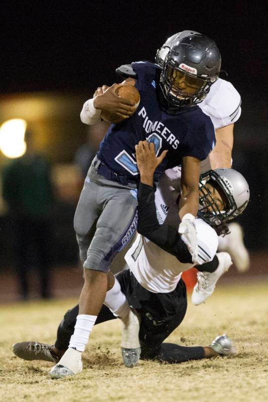 Green Valley’s Daunte Watson (1) tackles Canyon Springs’ Jayvion Pugh (3) in the ...