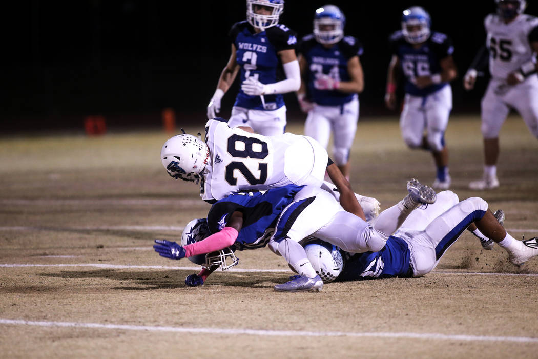 Foothill’s Braeden Wilson (28), top, is tackled by Basic during the first quarter of a ...