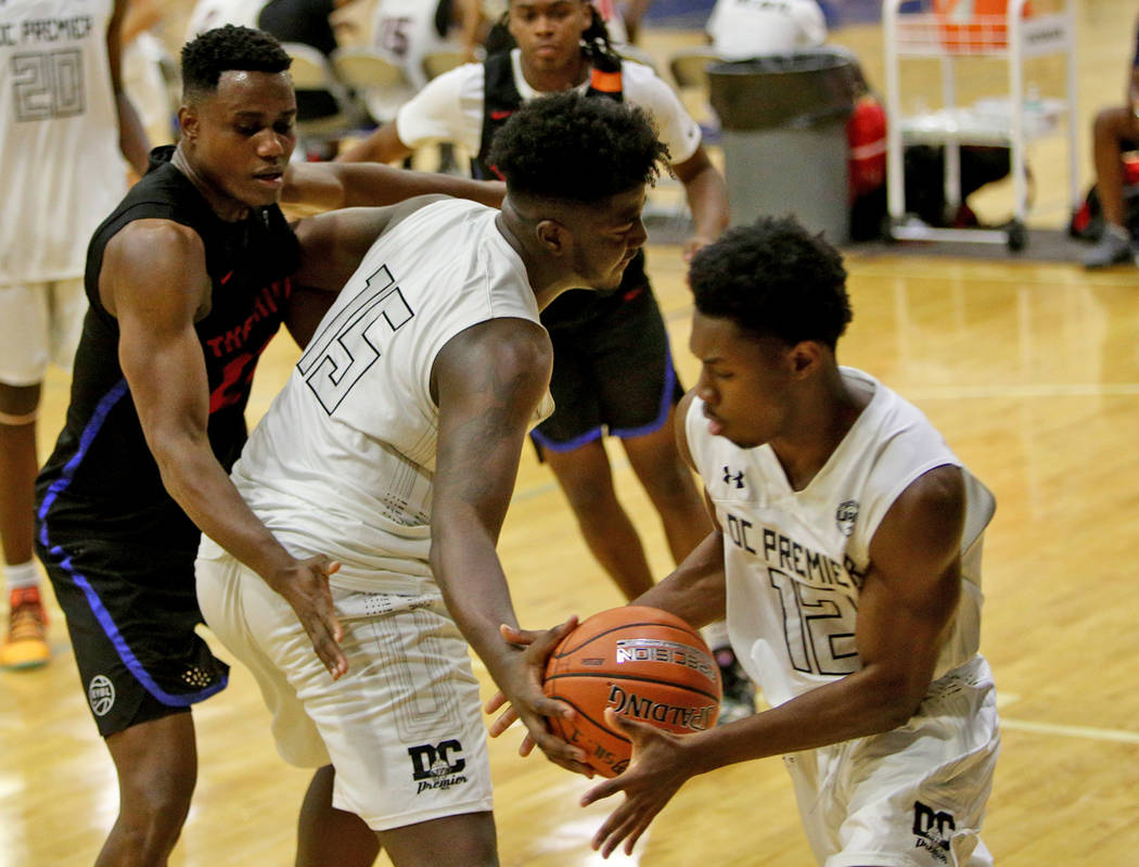 DC Premier’s Makhi Mitchell (15) passes to his teammate Joshua Wallace (12) while bloc ...