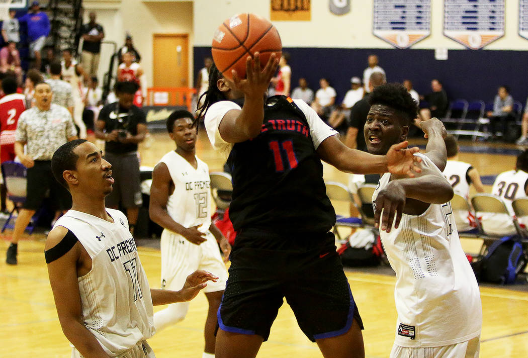 The Truth’s Earvin Knox goes up for a basket between DC Premier’s Mekhi Long, left, and ...