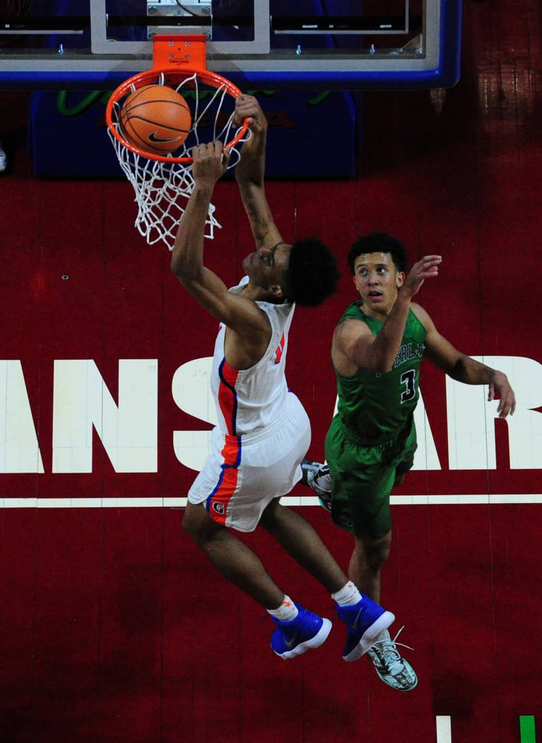 Bishop Gorman center Isaiah Cottrell dunks in front of Overland (Colo.) guard Tuscson Reddin ...