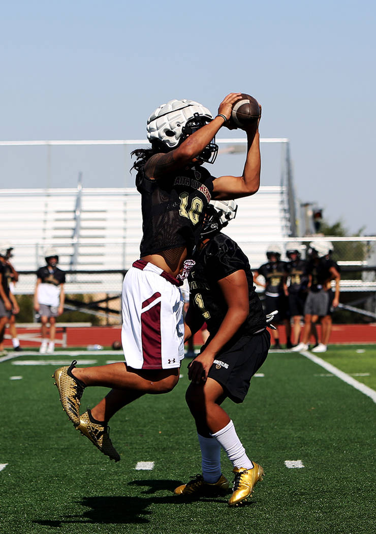 Taimani McKenzie (10) catches the ball during a drill at Faith Lutheran football team practi ...