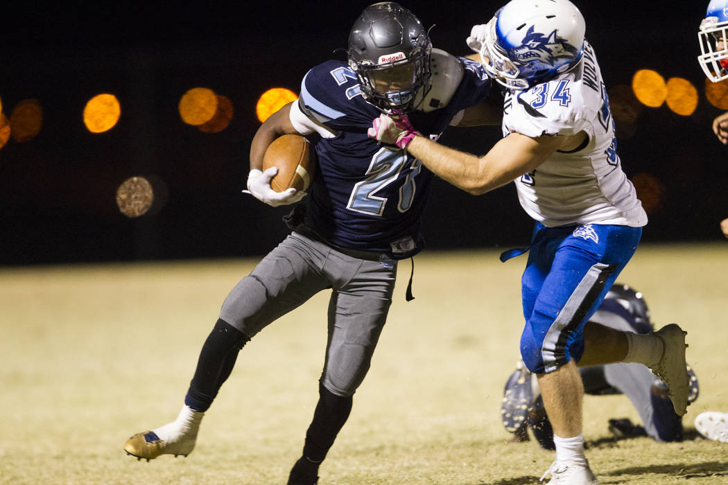 Canyon Spring’s DiaMante Burton (2) runs the ball against Basic’s Trace Evans (3 ...