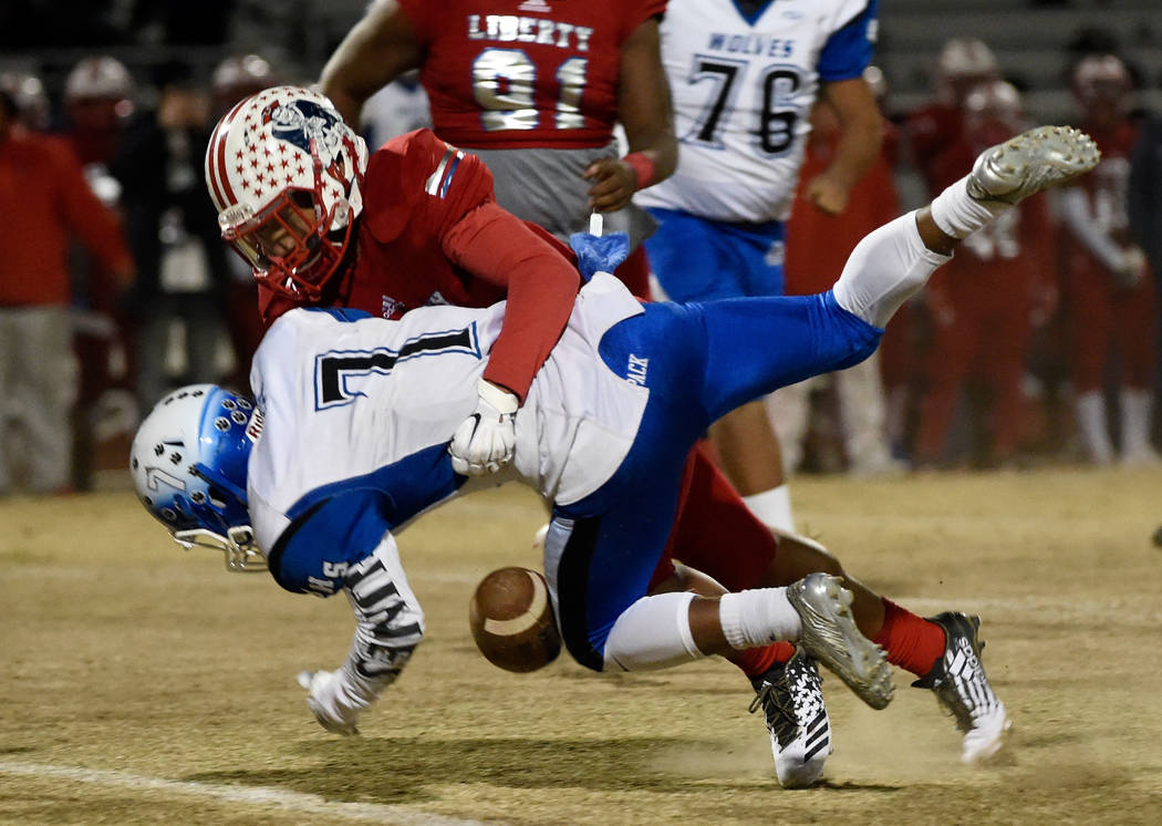 Basic’s Dorian McAllister (7) drops the ball after being hit by Liberty’s Austin ...