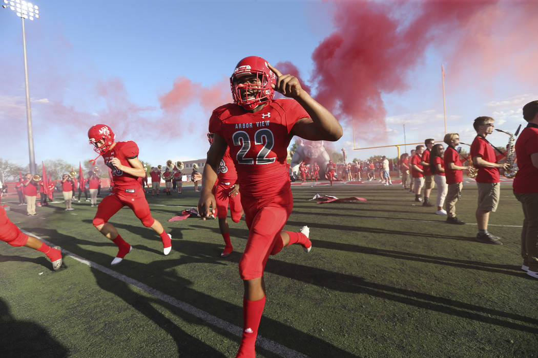 Arbor View Aggies defensive end Zavier Alston (22) and his team hit the field before playing ...