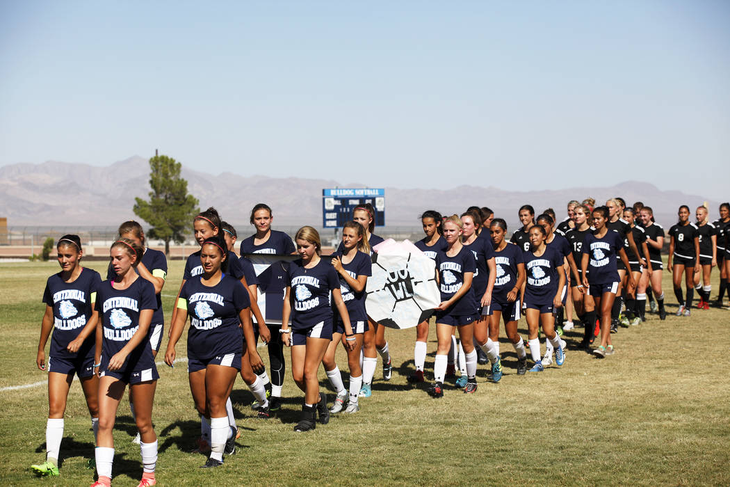 Palo Verde High School and Centennial High School soccer teams cross the field with a poster ...
