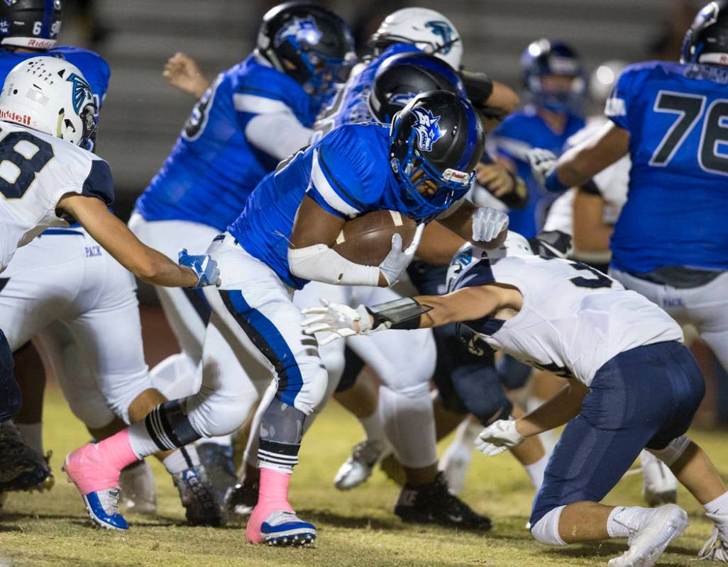 Basic running back Dorian Mcallister (21), center, carries there ball past Foothill defender ...