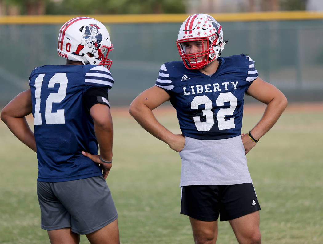 Liberty safety Austin Fiaseu, 12, and linebacker Kyle Beaudry, 32 during practice at the sch ...