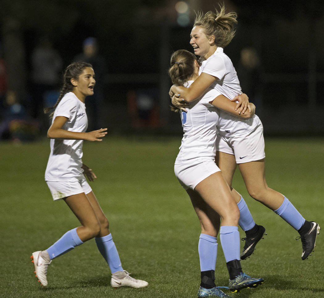 Foothill’s Annalise Huber (19) and Aqui Williams (13) embrace after the Falcons scored ...