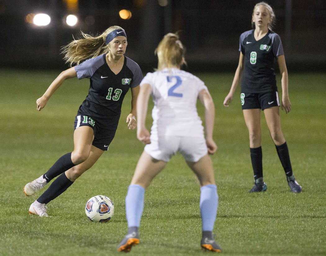 Green Valley sophomore midfielder Sydney Thomas (13) pushes the ball up field past Foothill ...