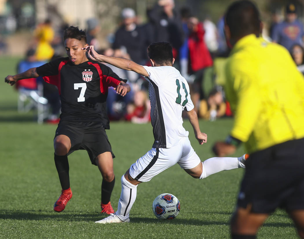 Palo Verde’s Tyler Olenak (13) looks to kick the ball past Las Vegas’ Luis Herna ...