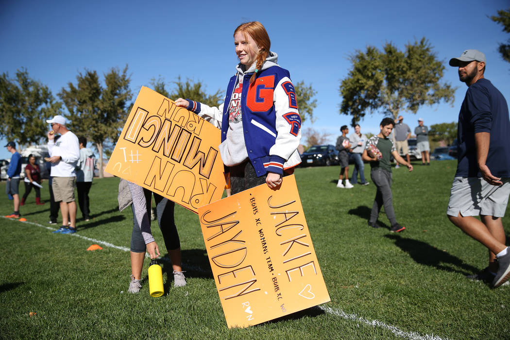 Bishop Gorman junior Sara Gillett, 16, carries signs in support of runners competing in the ...
