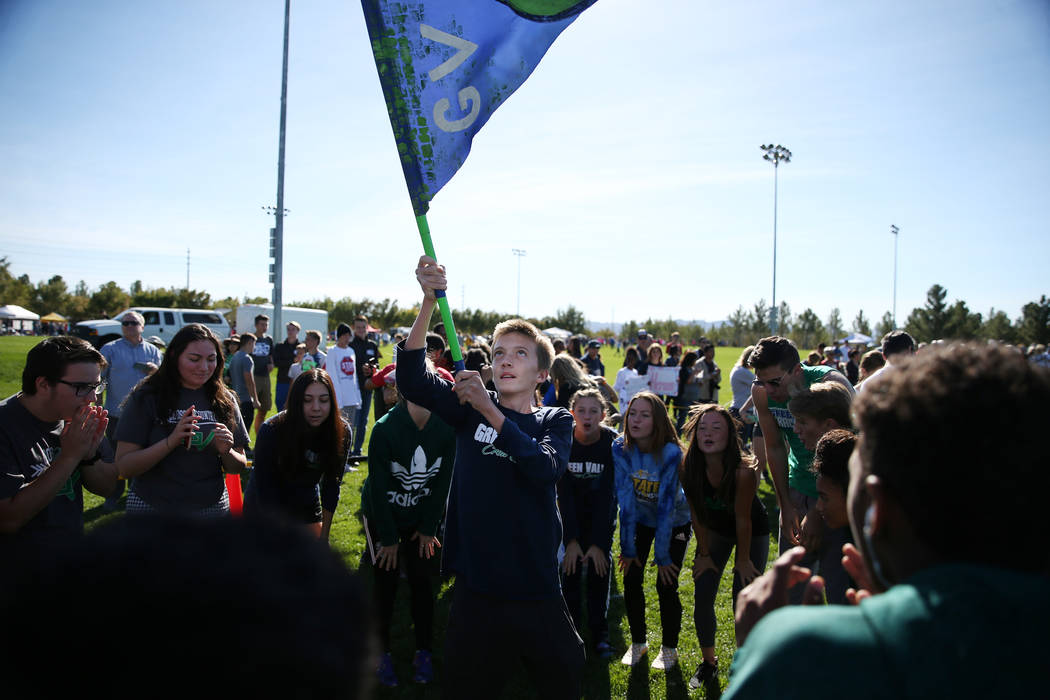 Green Valley freshman Jeffrey Welsh, 15, waves a Green Valley flag during a chant before the ...