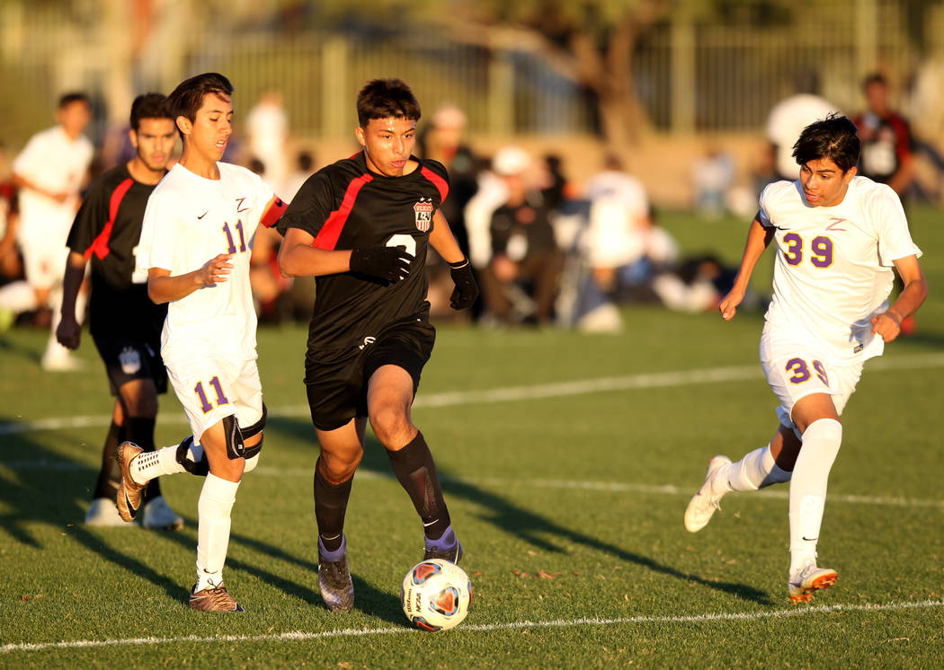 Las Vegas’ Daniel Rangel (8) moves the ball between Durango’s Christopher Bramas ...