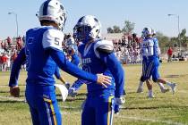 Moapa Valley’s Chase Hoy, left, congratulates quarterback Luke Bennett after his first ...