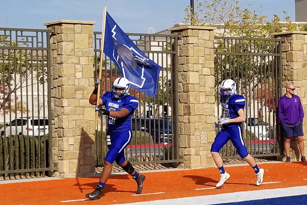Doogie Harvey leads Needles onto the field before the Class 2A state championship game at Bi ...