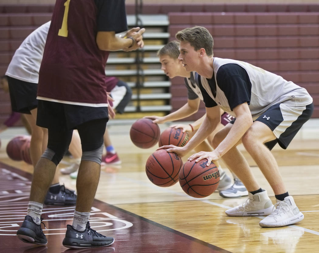 Faith Lutheran senior guard Brevin Walter, right, works through a dribbling drill during pra ...