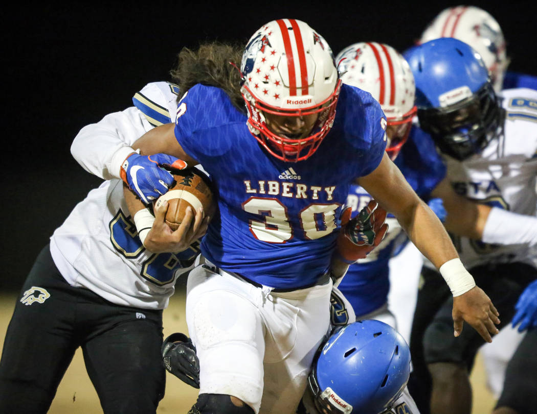 Liberty’s Zyrus Fiaseu (30) runs with the ball while under pressure from the Sierra Vi ...