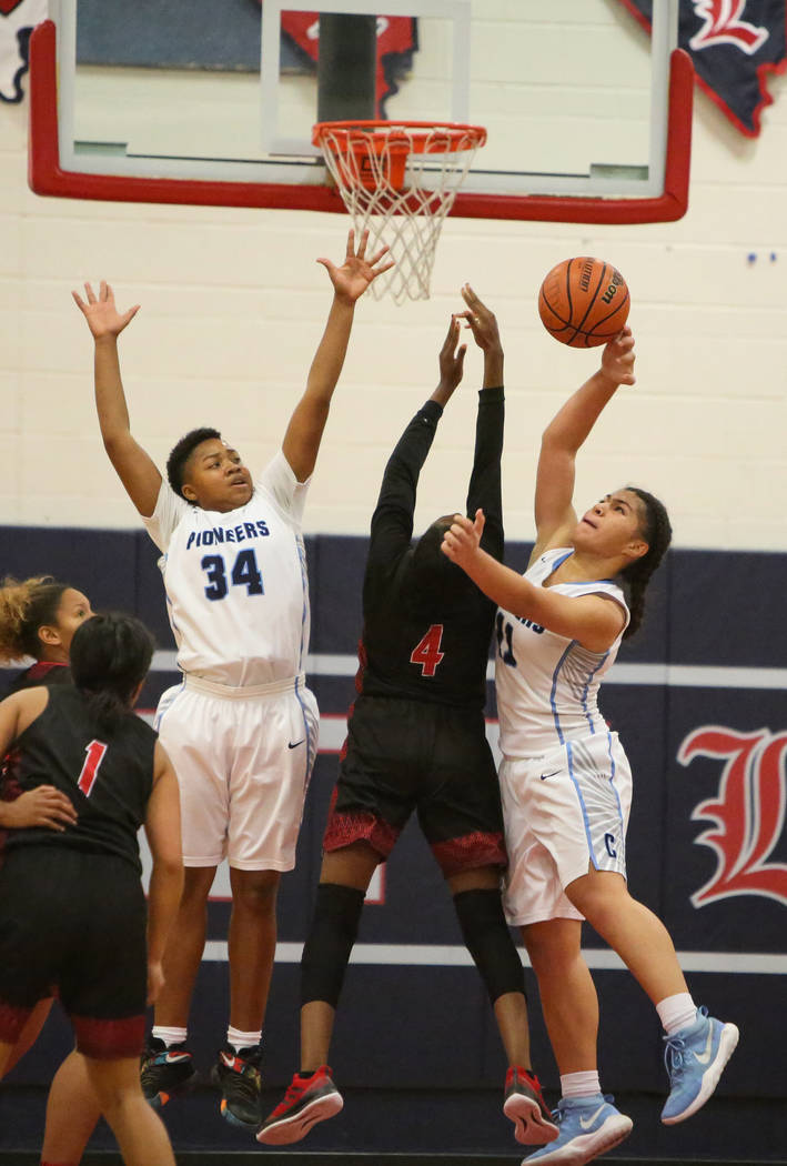 Canyon Spring’s Ja’moni Brown (34), left, and Jeanette Fine (11) block the ball ...