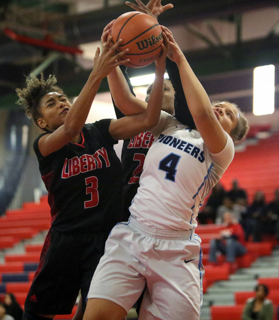 Liberty’s Journie Augmon (3) and Olivia Children (23) fight for the ball against Canyo ...