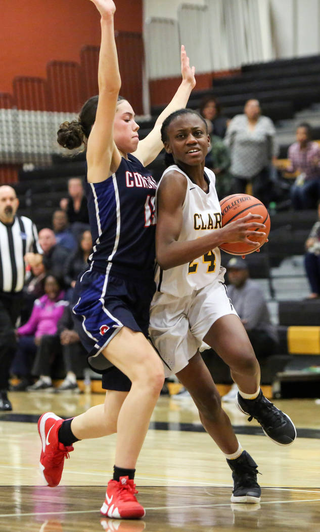 Clark’s Al’ynnay Godfrey (24) runs with the ball while under pressure from Coron ...