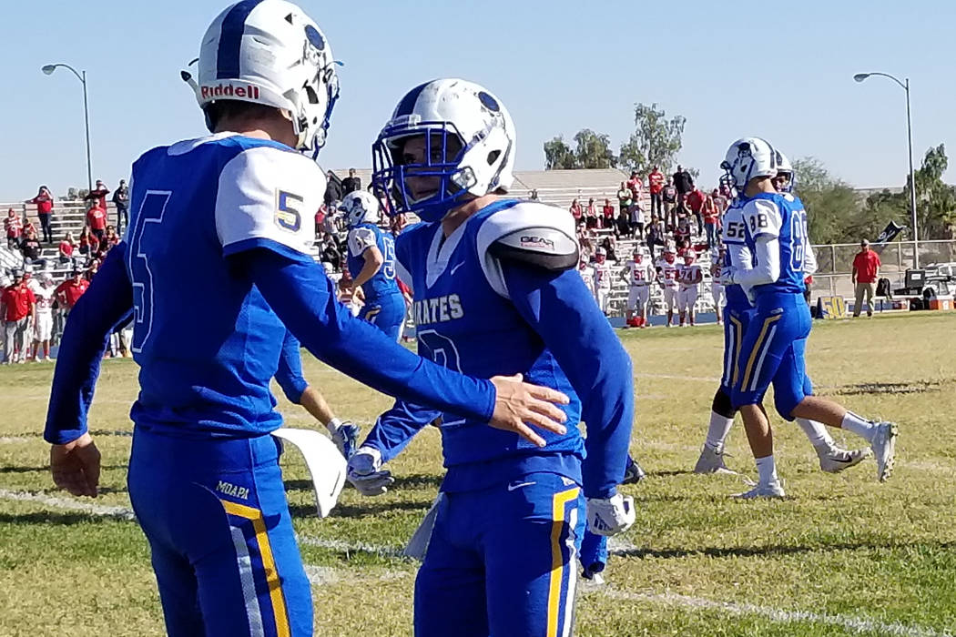 Moapa Valley’s Chase Hoy, left, congratulates quarterback Luke Bennett after his first ...