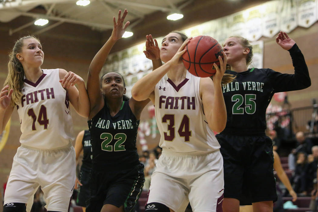 Faith Lutheran’s Kelsey Howryla (34) looks to shoot the ball while under pressure from ...