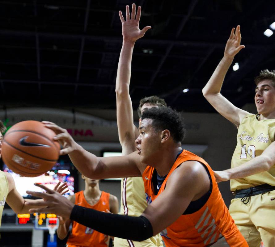 Bishop Gorman freshman forward Max Allen (12) makes a baseline pass around Lone Peak senior ...