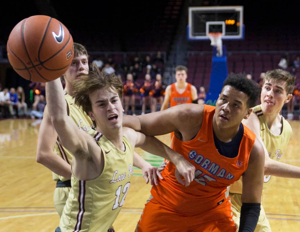Bishop Gorman freshman forward Max Allen (12) fights for a loose ball with Lone Peak senior ...
