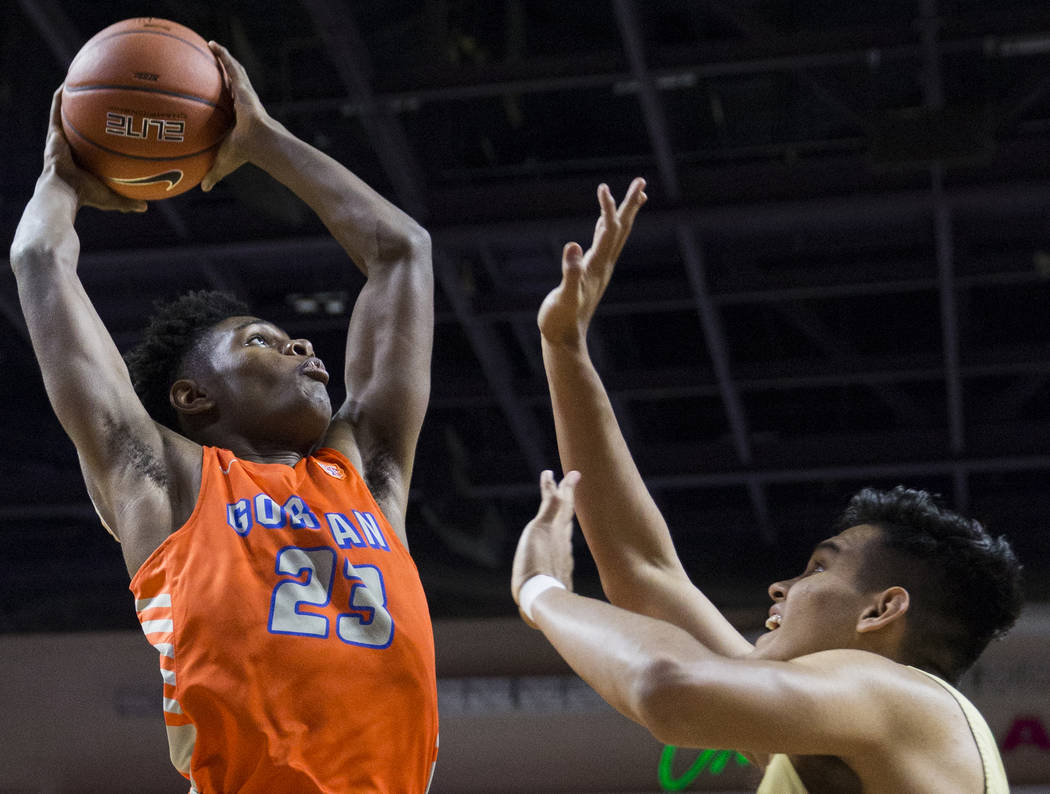 Bishop Gorman junior forward Mwani Wilkinson (23) elevates for a dunk over Lone Peak junior ...