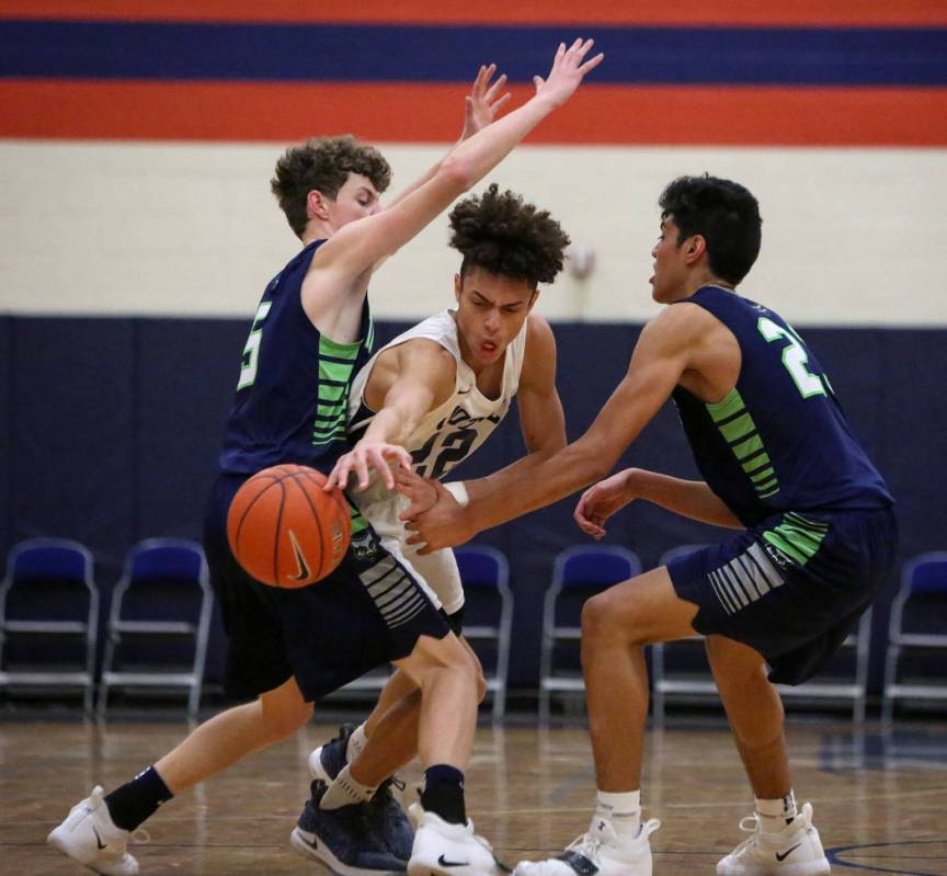 Foothill’s Jace Roquemore (22) reaches for the ball while under pressure from Timpanog ...