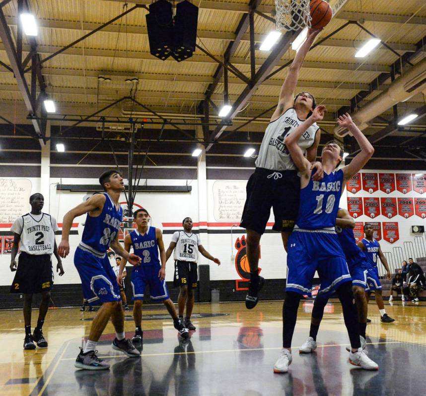 Trinity’s Enrique Lopez Baez (14) takes a shot while under pressure from Basic’s ...