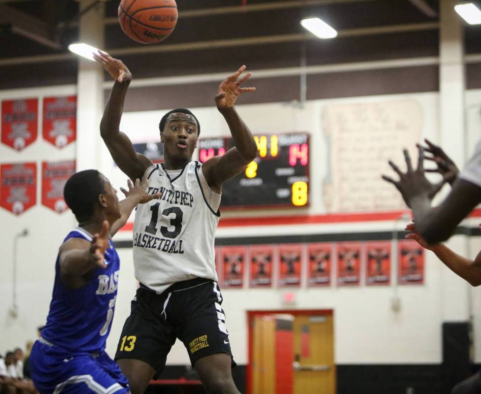 Trinity’s Zaba Bangala (13) passes to a teammate while under pressure from Basic&#8217 ...