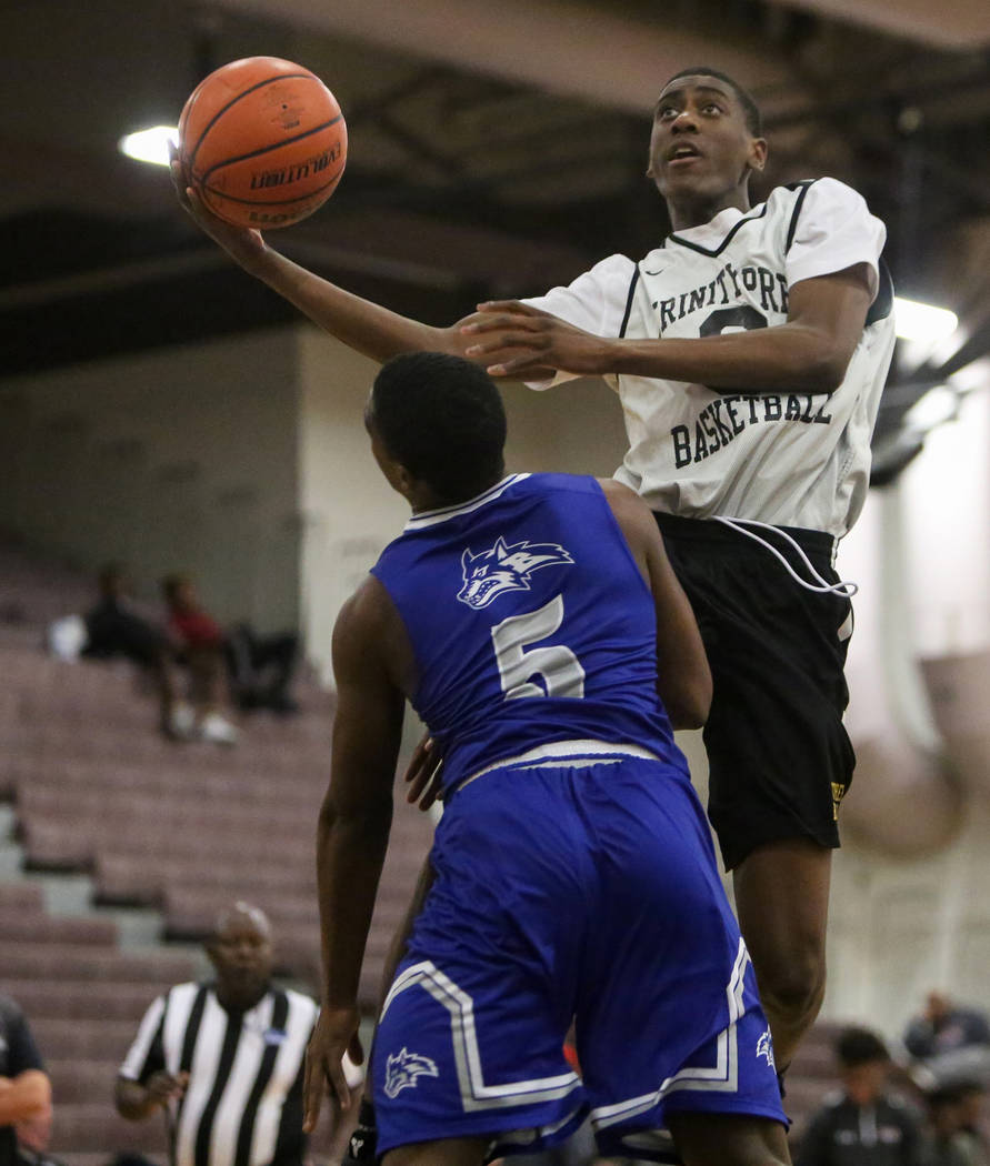 Trinity’s Kevin Giles (3) jumps up to take a shot while under pressure from Basic&#821 ...