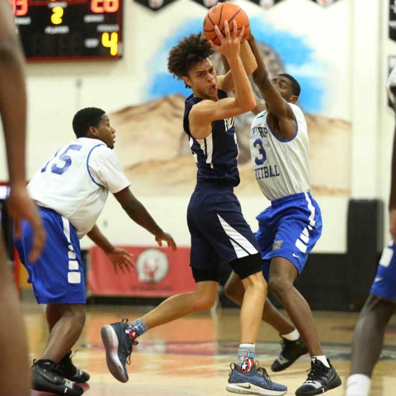 Foothill’s Jace Rocequemore (22), center, is pressured by Trinity’s Kevin Giles ...