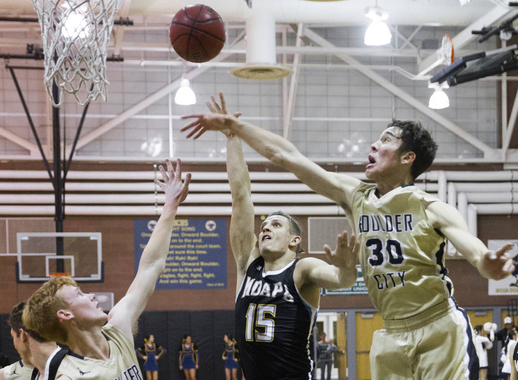 Moapa Valley senior forward Jessup Lake (15) shoots over Boulder City sophomore forward Etha ...