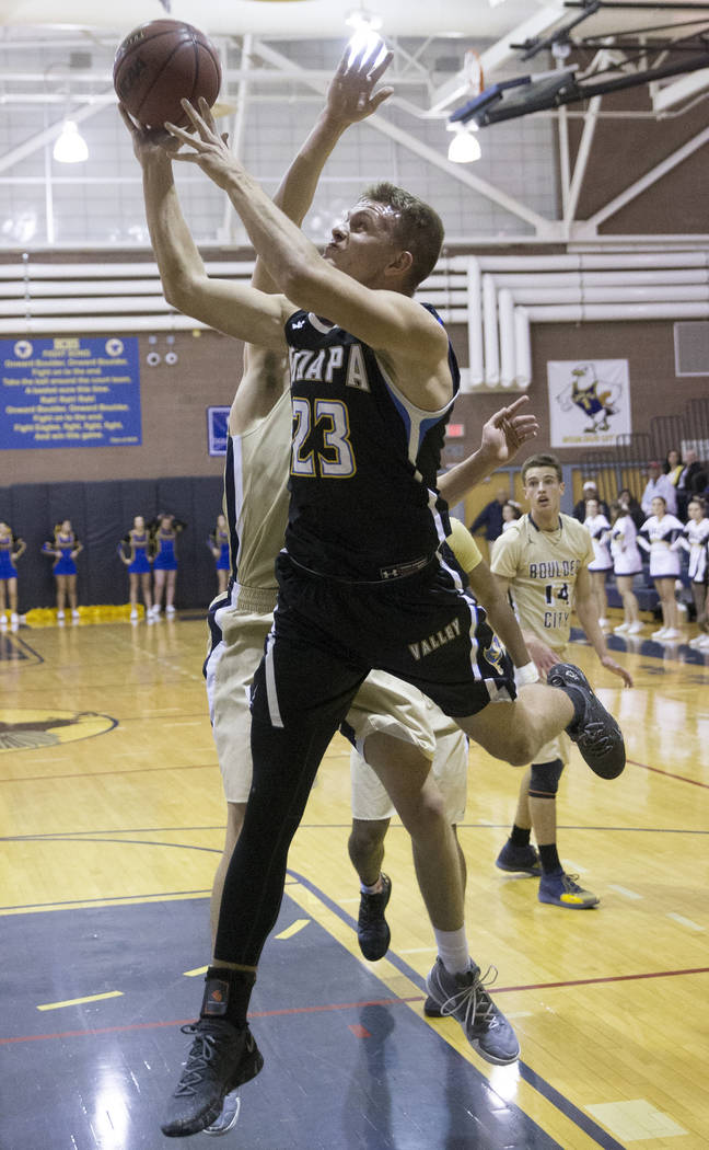 Moapa Valley senior forward Derek Reese (23) drives baseline past Boulder City sophomore for ...