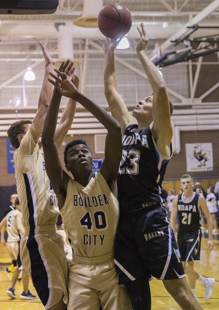 Moapa Valley senior forward Derek Reese (23) fights for a rebound with Boulder City junior f ...