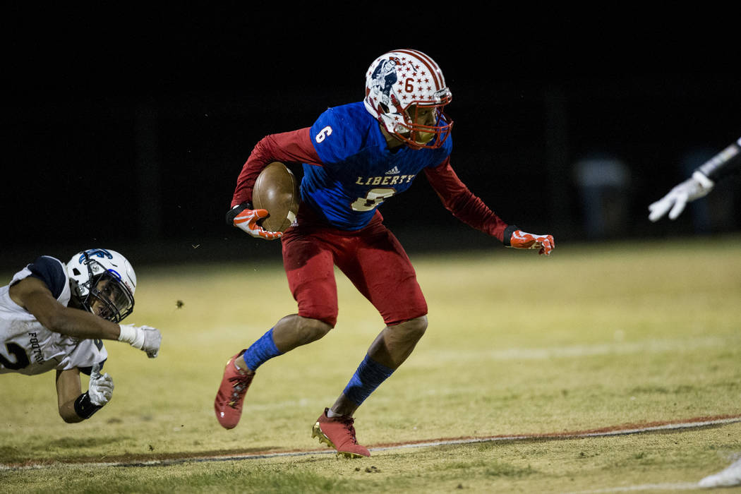 Liberty’s Cervontes White (6) runs the ball against Foothill in their football game at ...