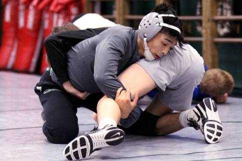 Green Valley High School junior wrestler Steele Dias, top, works on a move with his training ...