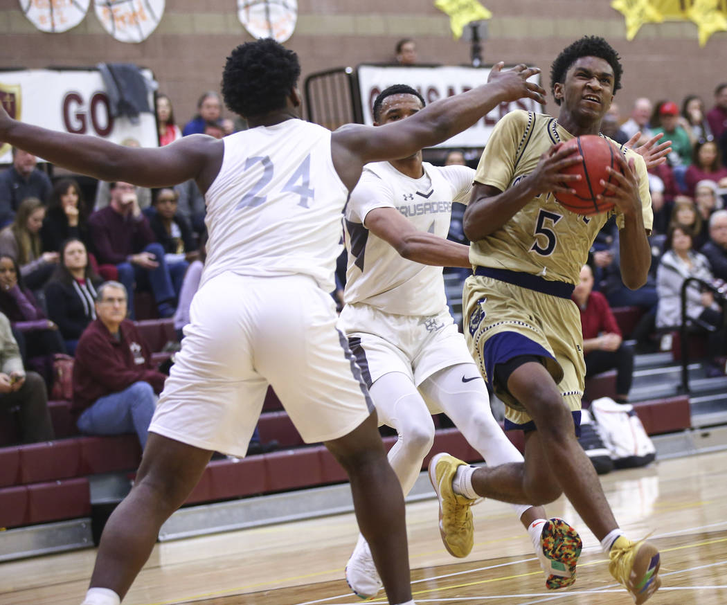 Cheyenne’s Glenn Taylor (5) drives to the basket past Faith Lutheran’s D.J. Heck ...